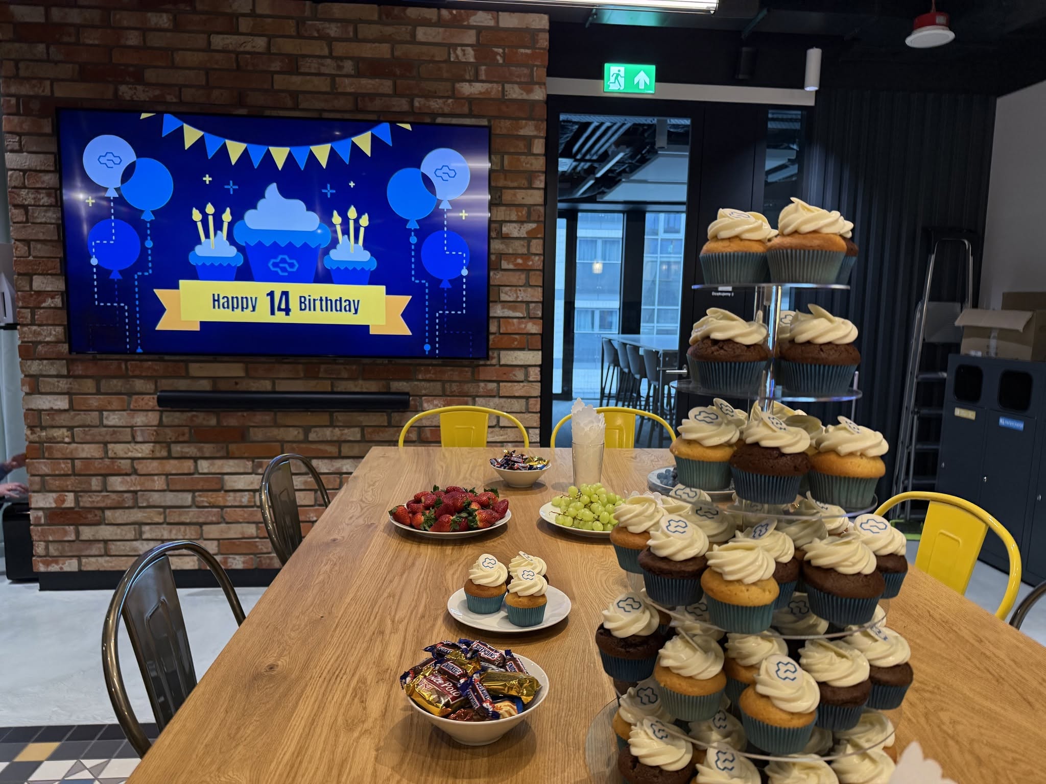 CloudTechnologies 14th birthday office celebration — cupcake tower and TV signage